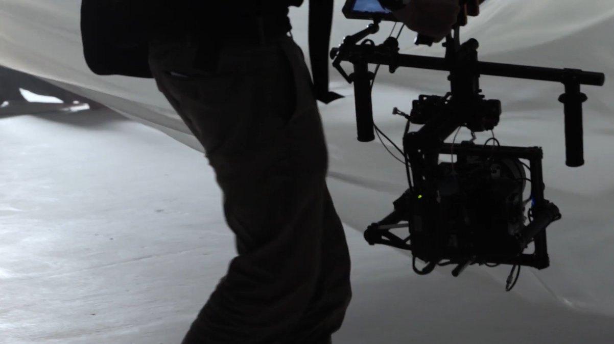 Person trägt eine Kamera auf einem Gimbal durch ein Studio